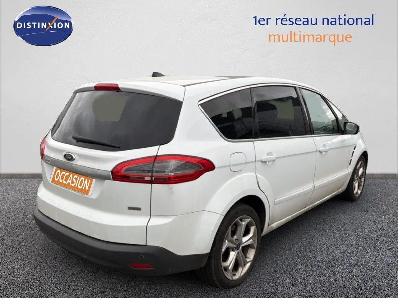 Vue 3/4 arrière droite d'un Ford S-MAX blanc de 2013 avec vitres teintées et jantes alliage.