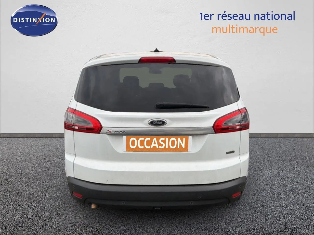 Vue arrière d'un Ford S-MAX blanc de 2013 avec hayon fermé et feux arrière rouges allongés.