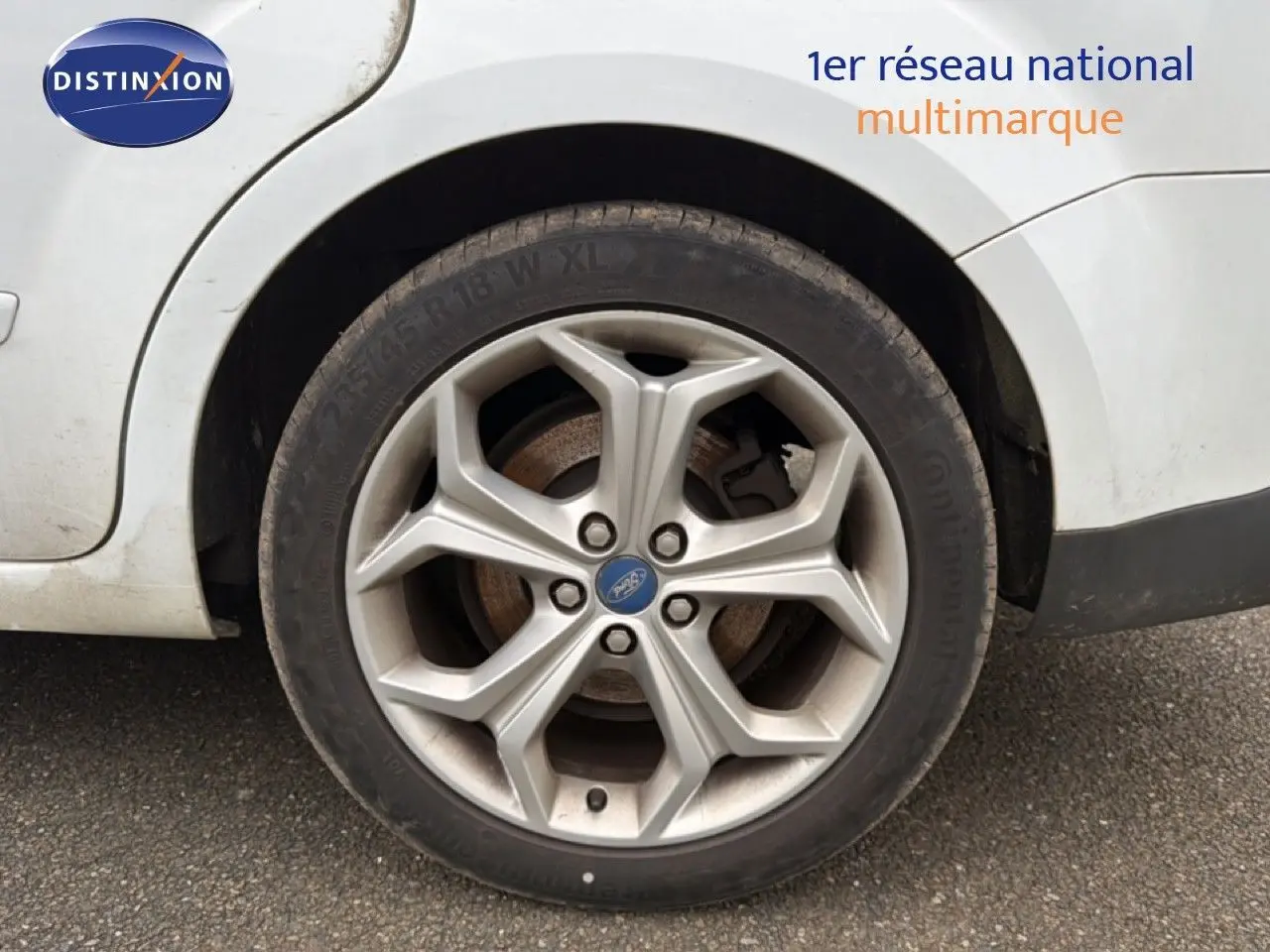 Gros plan sur la roue arrière droite d’une Ford S-MAX blanche de 2013 avec jante alliage 18 pouces.