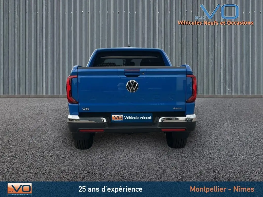 Vue arrière d'un Volkswagen Amarok Simple Cabine bleu 2025 avec logo VW et feux arrière LED distinctifs.