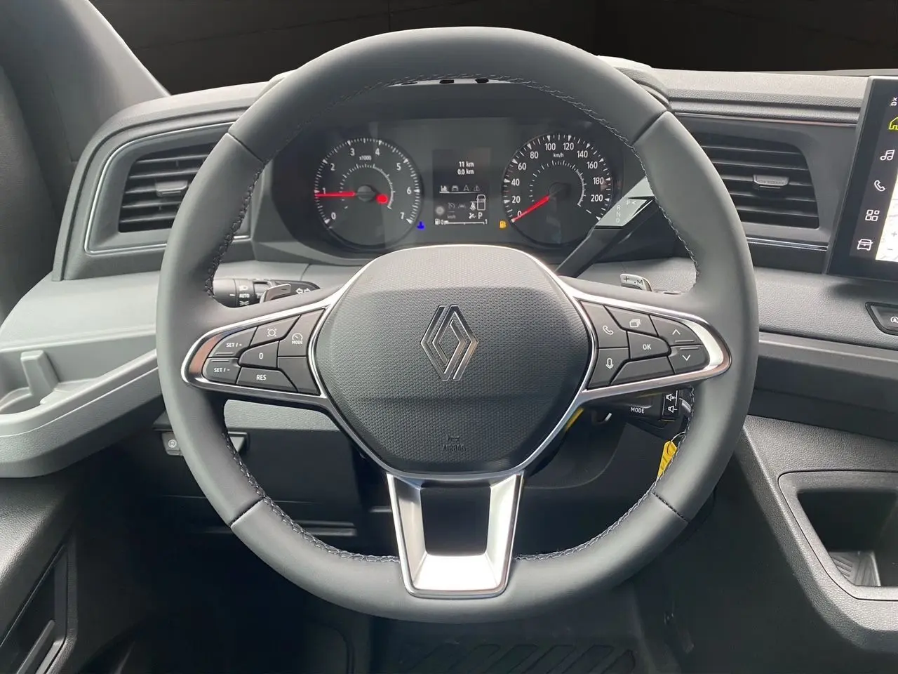 Vue frontale du volant noir de Renault Master 2025 avec commandes intégrées et tableau de bord numérique.