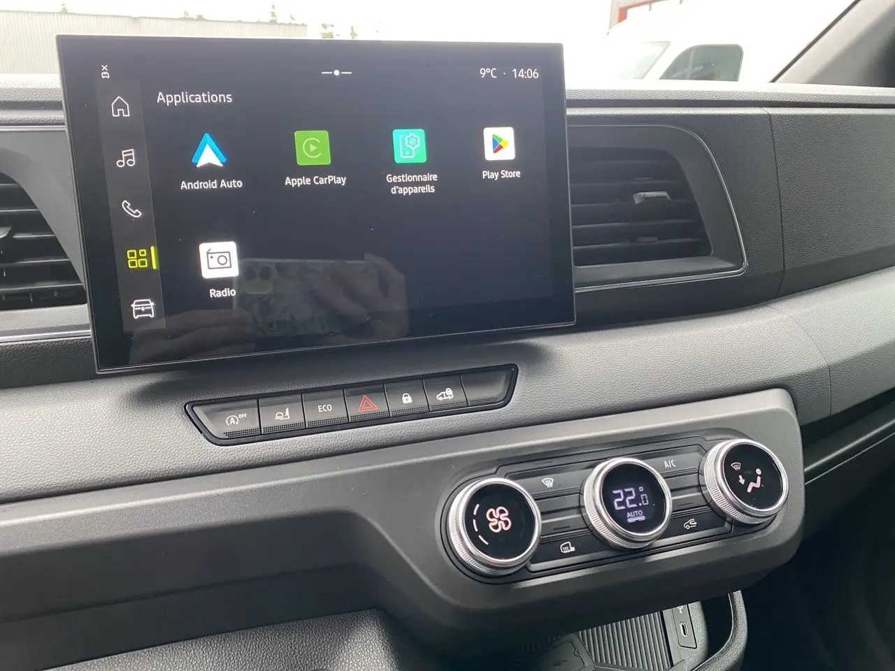 Vue rapprochée de la console centrale du Renault Master blanc, avec écran tactile et commandes de climatisation digitales.