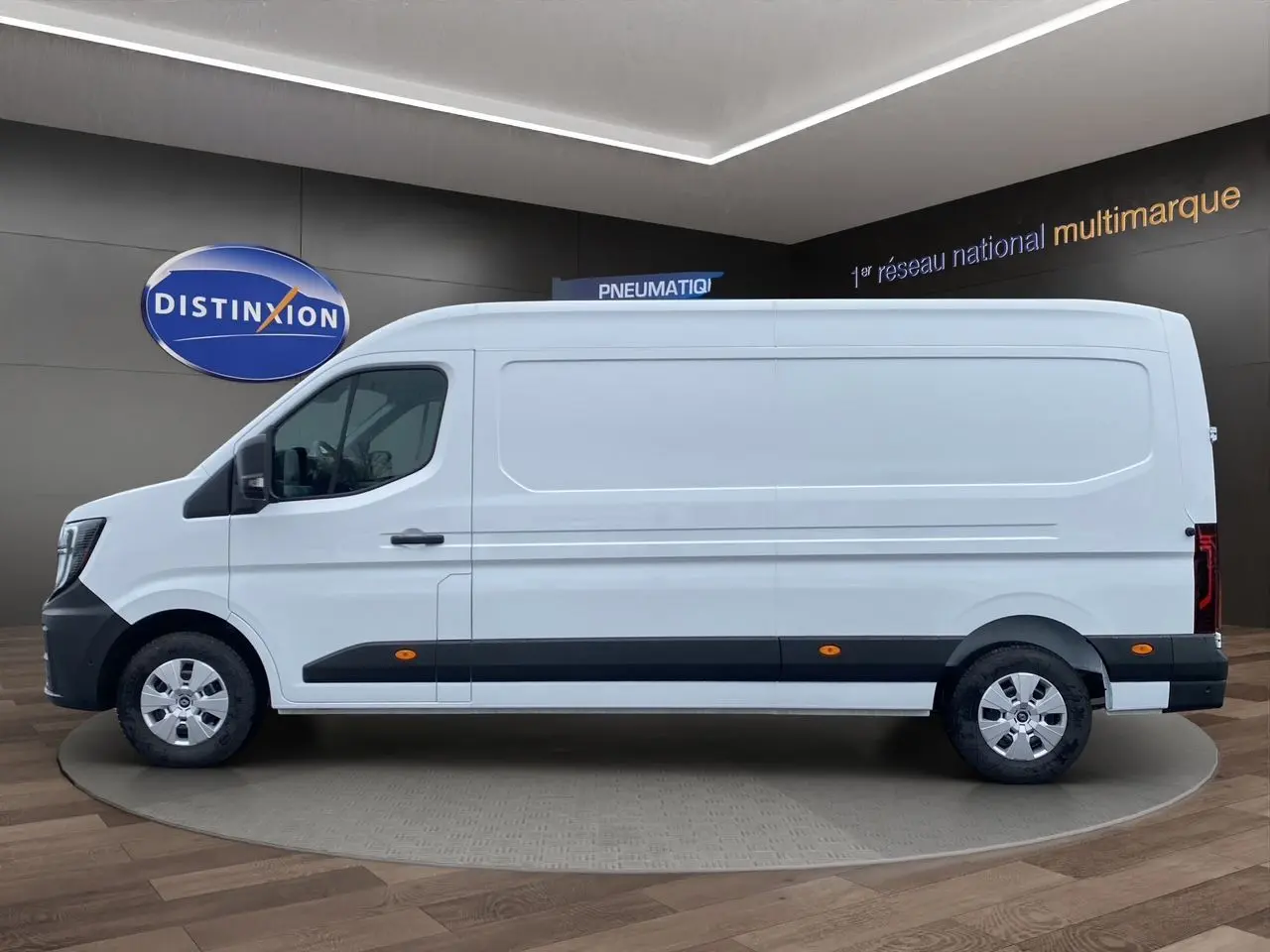 Renault Master blanc en vue profil côté gauche, avec protections noires et jantes argentées visibles.