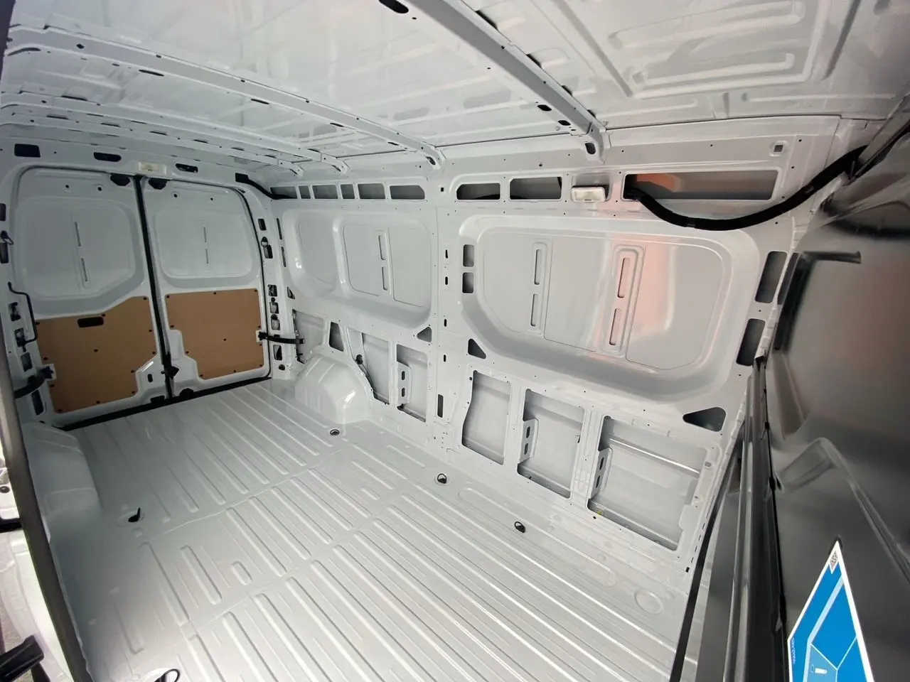 Vue intérieure de la zone de chargement blanche du Renault Master 2025, montrant les parois et plancher tôlés.