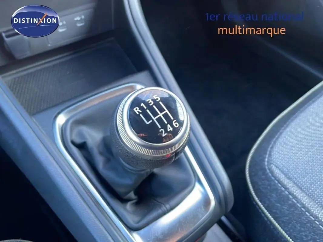 Gros plan sur le levier de vitesses manuel noir du Renault Captur rouge 2025, avec coutures apparentes sur la console.