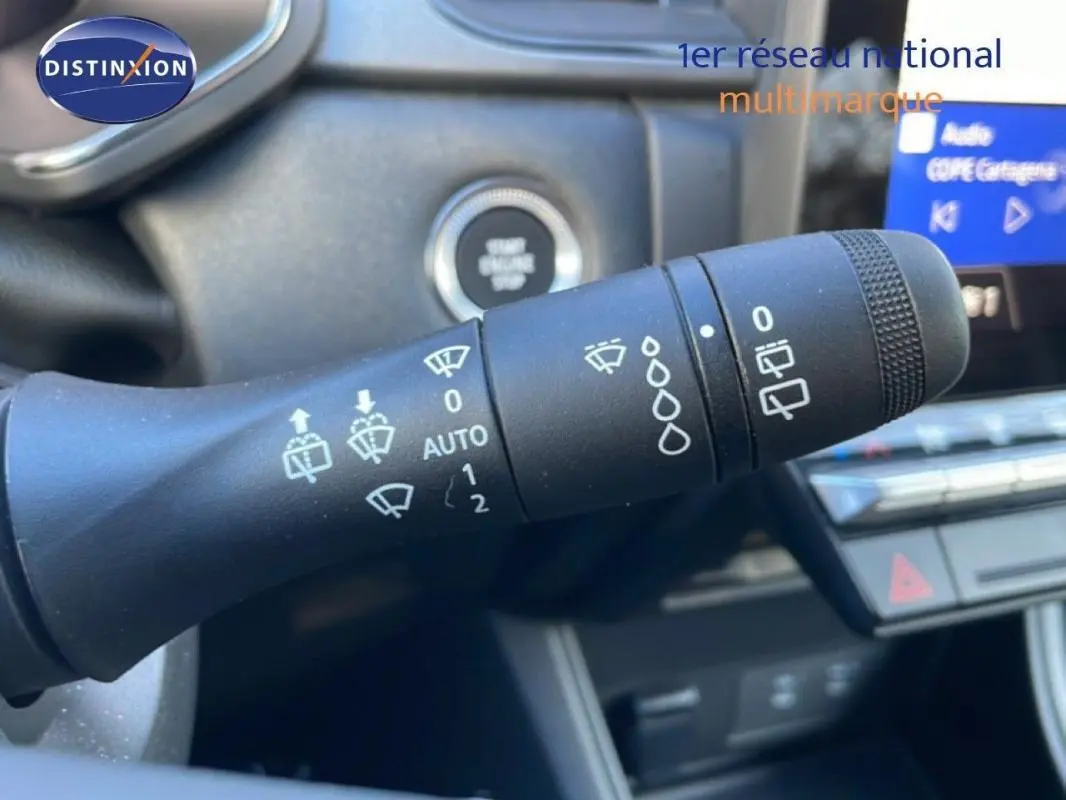 Gros plan sur la commande de détecteur de pluie dans l'habitacle du Renault Captur rouge 2025.