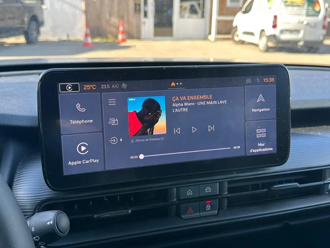 Écran tactile central du tableau de bord du Jeep Avenger gris, affichant la musique et les options connectées.