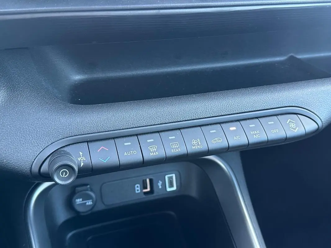 Détail de la console centrale du Jeep Avenger gris 2025, montrant les commandes climatisation et ports USB.