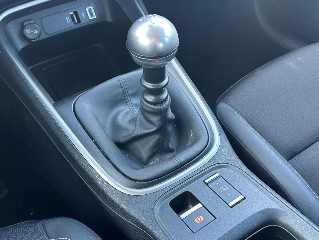 Le levier de vitesse manuel en cuir noir de la Jeep Avenger 2025, avec boutons frein à main et mode de conduite.