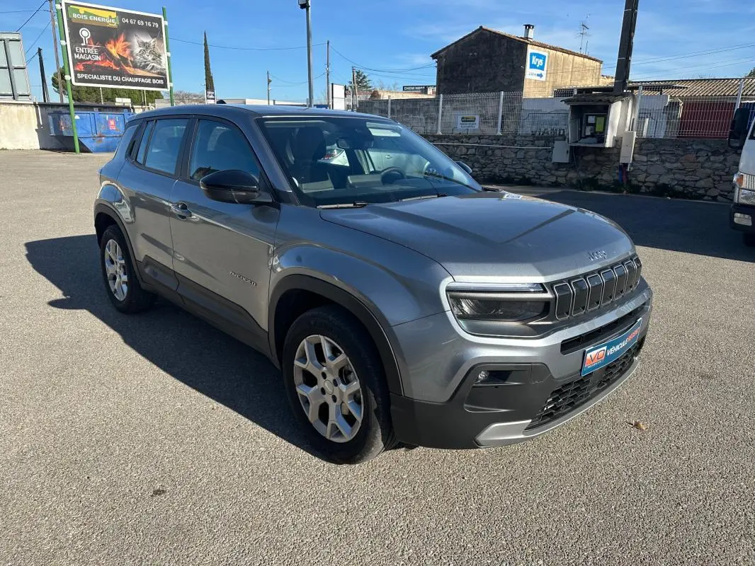 Jeep Avenger gris en 3/4 avant droit, mettant en valeur ses jantes alliage 17 pouces et ses phares LED distinctifs.