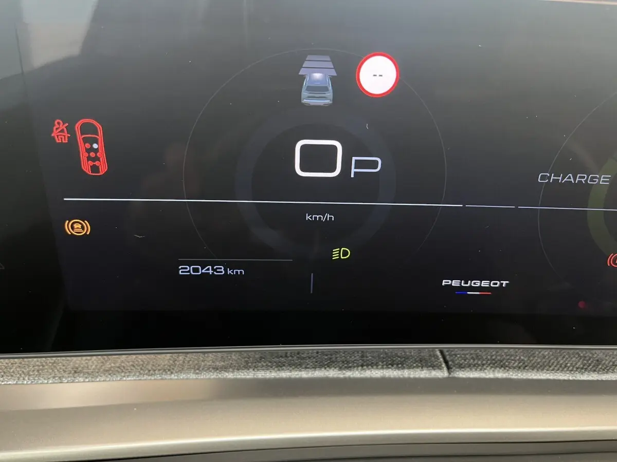 Affichage numérique du combiné d'instruments du Peugeot 5008 Hybrid blanc, montrant 2043 km et indicateurs de sécurité.