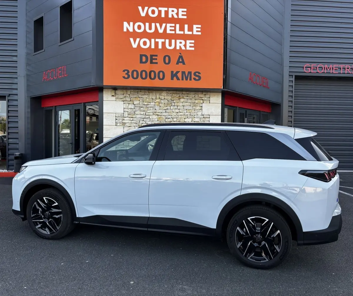 Peugeot 5008 blanc vue de profil côté gauche, SUV hybride avec jantes noires et toit noir contrasté.