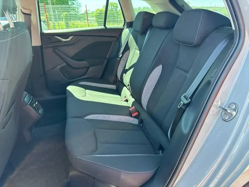 Vue latérale droite de l'intérieur arrière d'une Skoda Scala 2025 avec sièges tissu noir et gris et ceinture de sécurité visible.