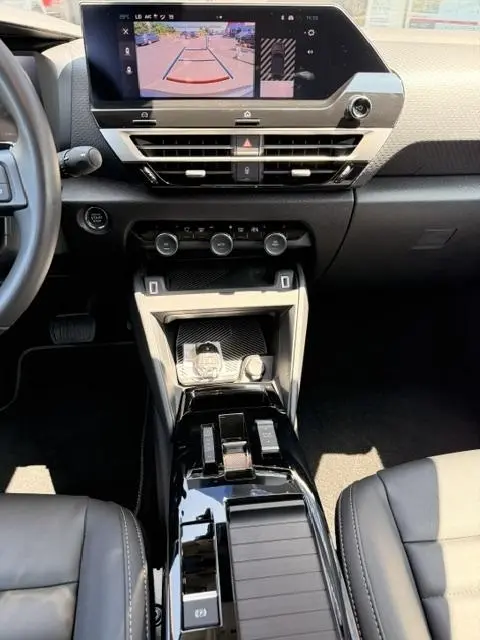 Vue intérieure centrée sur la console centrale et l'écran tactile affichant la caméra de recul du Citroën C4 gris foncé.