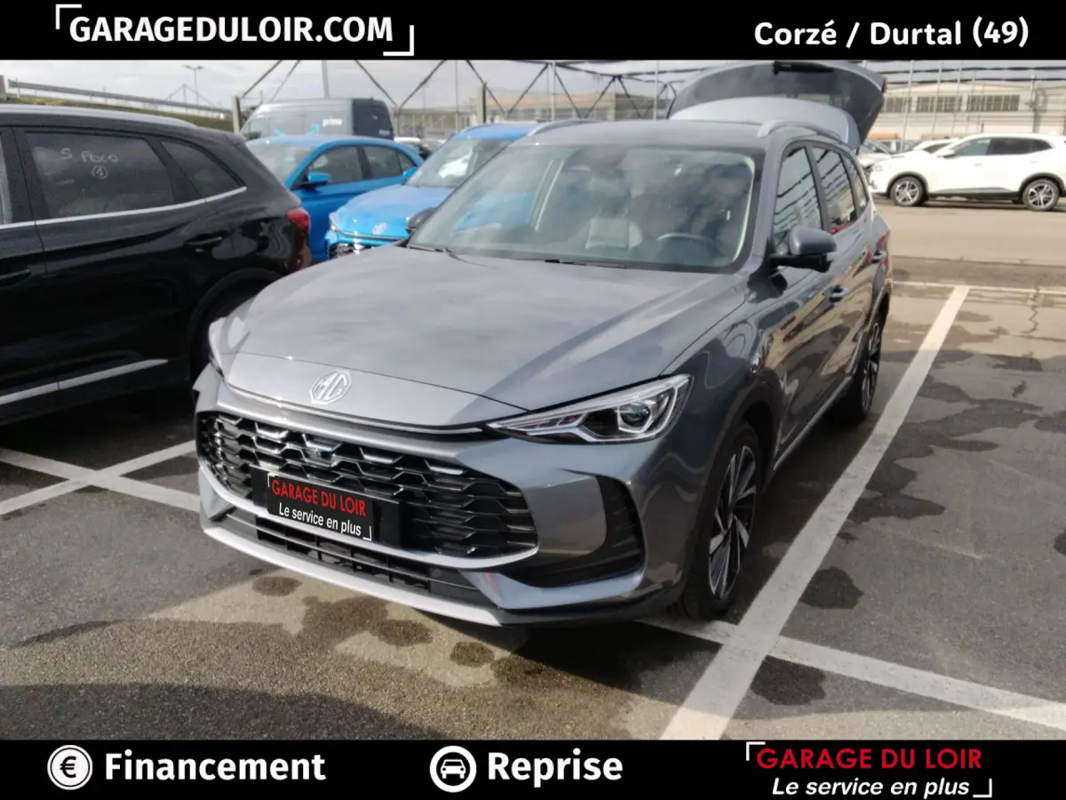 MG ZS 1.5L Hybrid+ Luxury gris clair vu en 3/4 avant droit sur parking avec calandre noire distinctive.