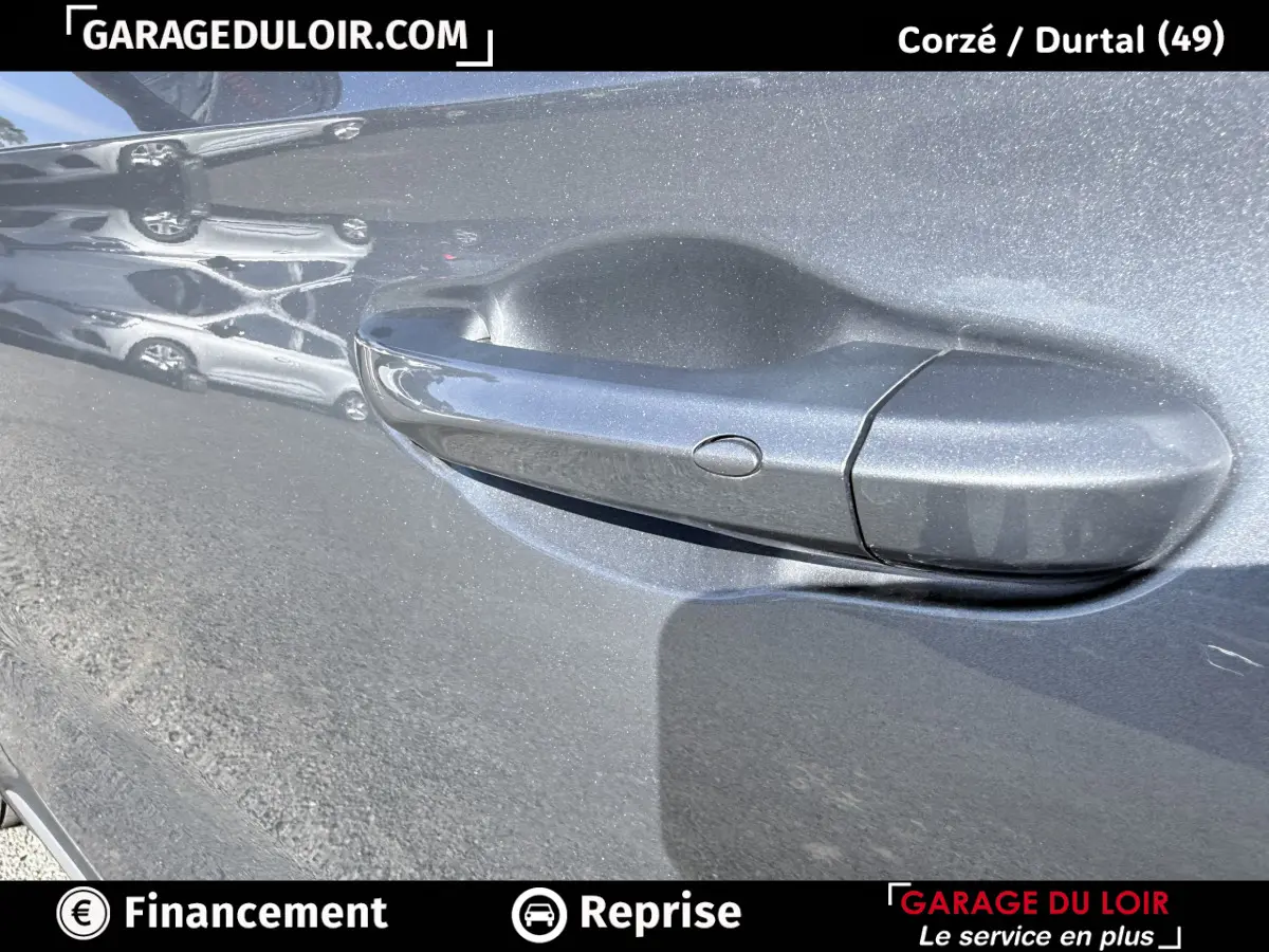 Poignée de porte gris clair du MG Motor ZS 1.5L Hybrid+ Luxury 2025 avec reflet et bouton de déverrouillage.