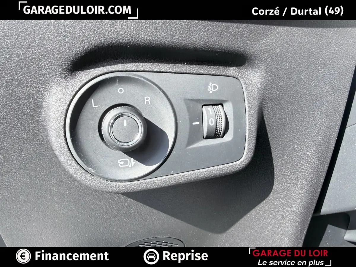 Gros plan sur la commande de réglage des rétroviseurs et des phares d’un MG ZS gris clair 2025.