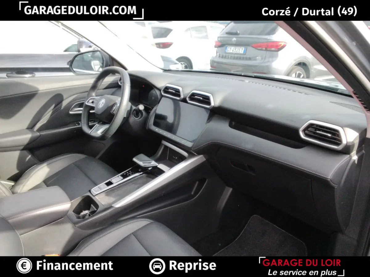 Intérieur noir du MG Motor ZS 1.5L Hybrid+ Luxury, vue côté conducteur avec tableau de bord et écran tactile central.