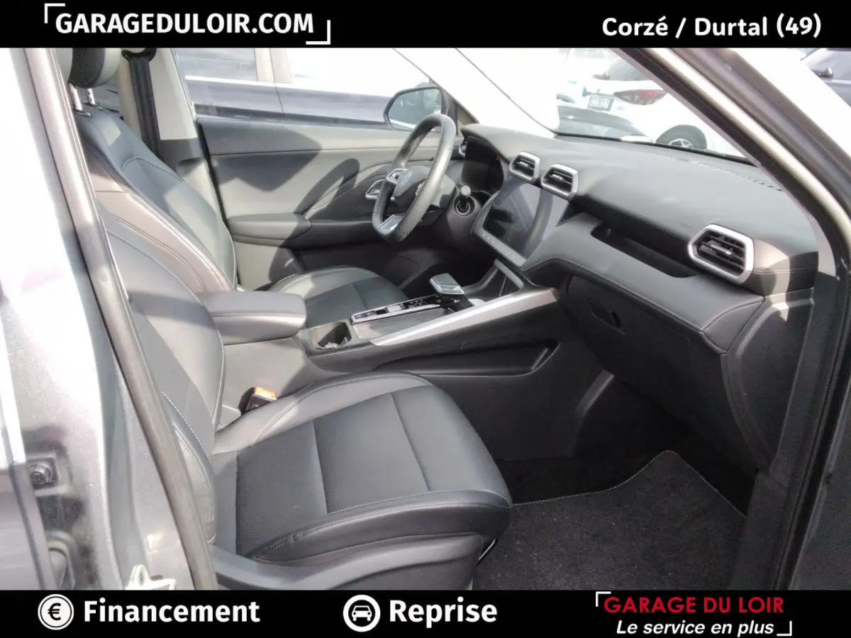 Intérieur avant droit du MG ZS gris clair 2025, sièges cuir noirs et tableau de bord avec écran tactile central.