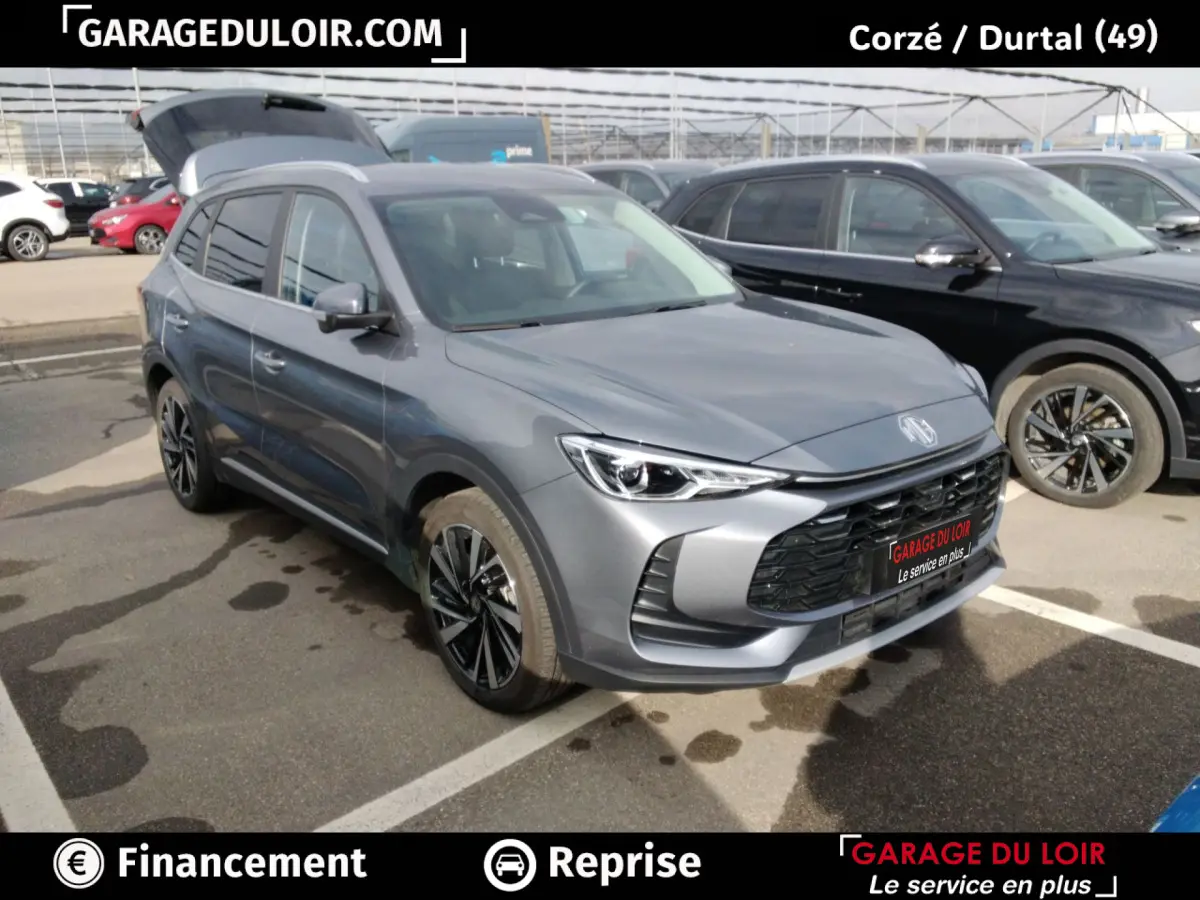 MG ZS gris clair en 3/4 avant droit, avec calandre noire et jantes alliage noires distinctives.