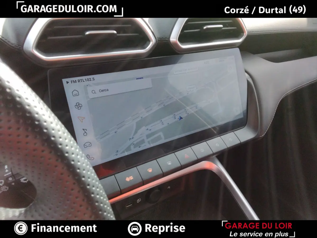 Vue intérieure du tableau de bord du MG Motor ZS gris clair, avec écran tactile central affichant la navigation.