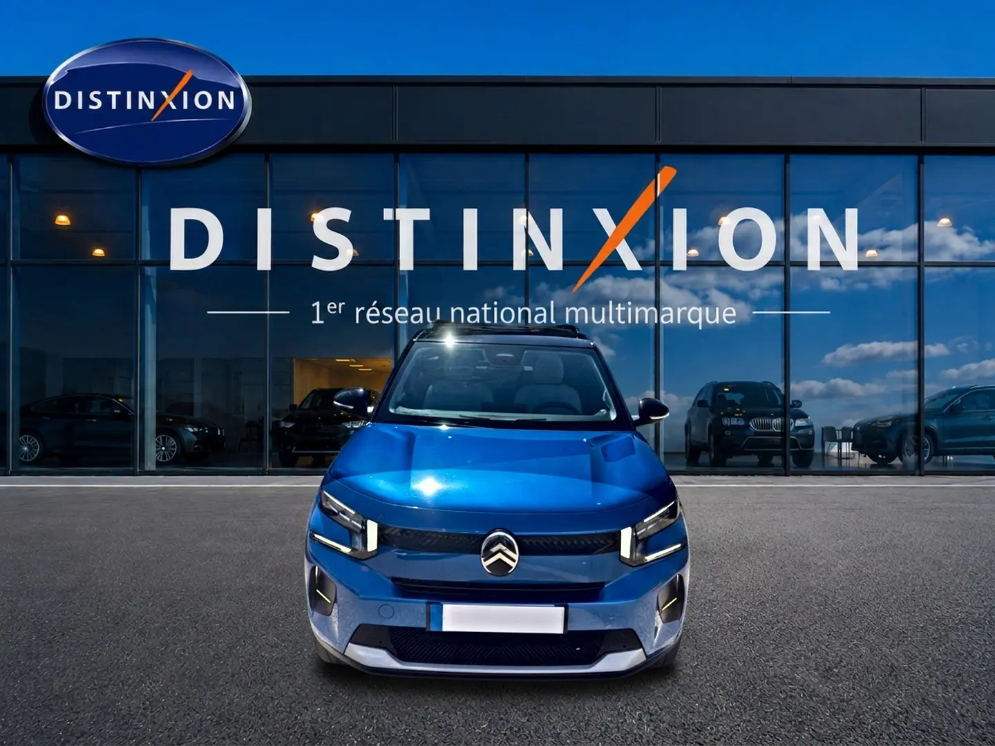 Vue avant d'une Citroën C3 1.2 turbo bleu 2025, avec phares LED et calandre distinctive, devant une vitrine Distinxion.