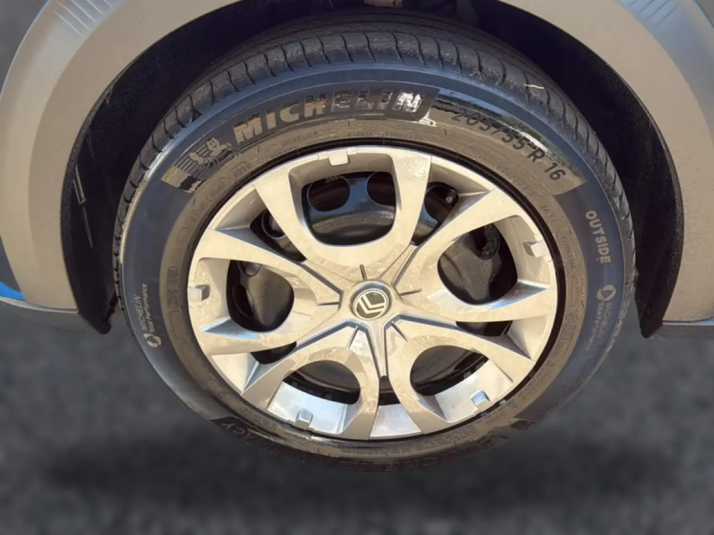 Gros plan sur la jante alu argentée et pneu Michelin d’une Citroën C3 bleu, côté avant droit.