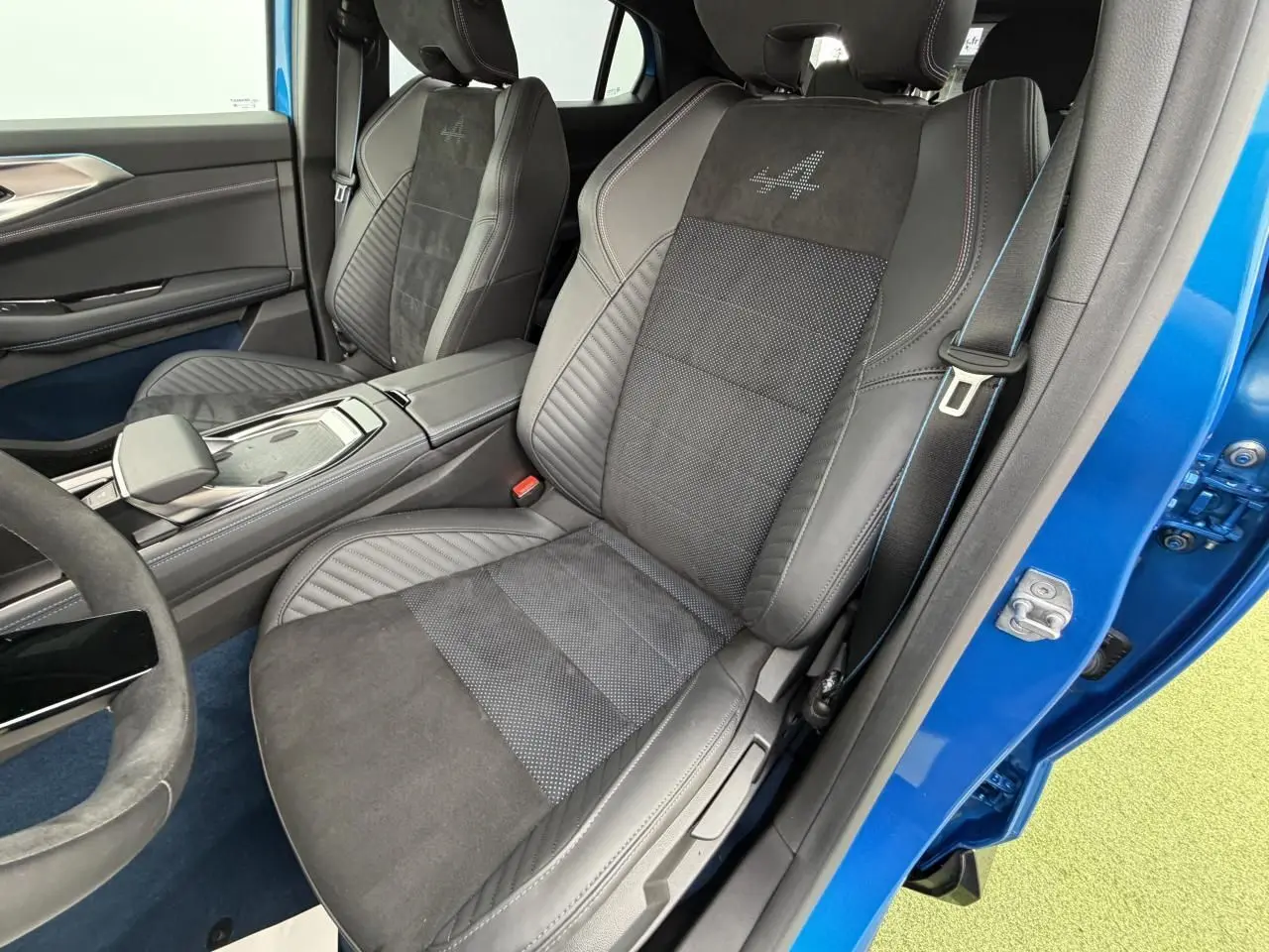 Vue intérieure côté conducteur du Renault Rafale Summit Blue 2025, sièges sport en Alcantara avec logo Alpine brodé.