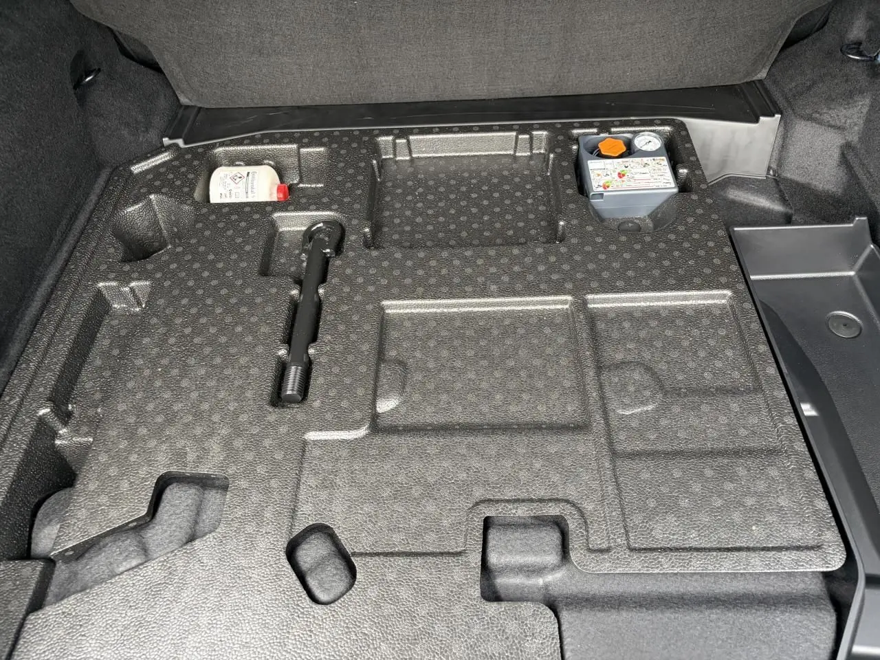 Vue du coffre ouvert du Renault Rafale 2025, montrant le rangement en mousse noire avec accessoires intégrés.