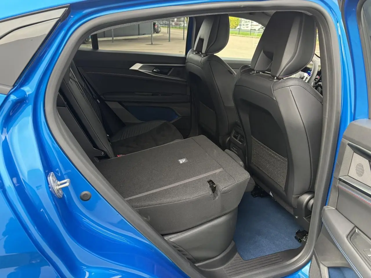 Vue intérieure côté gauche de la banquette arrière rabattue d’un Renault Rafale Summit Blue 2025.