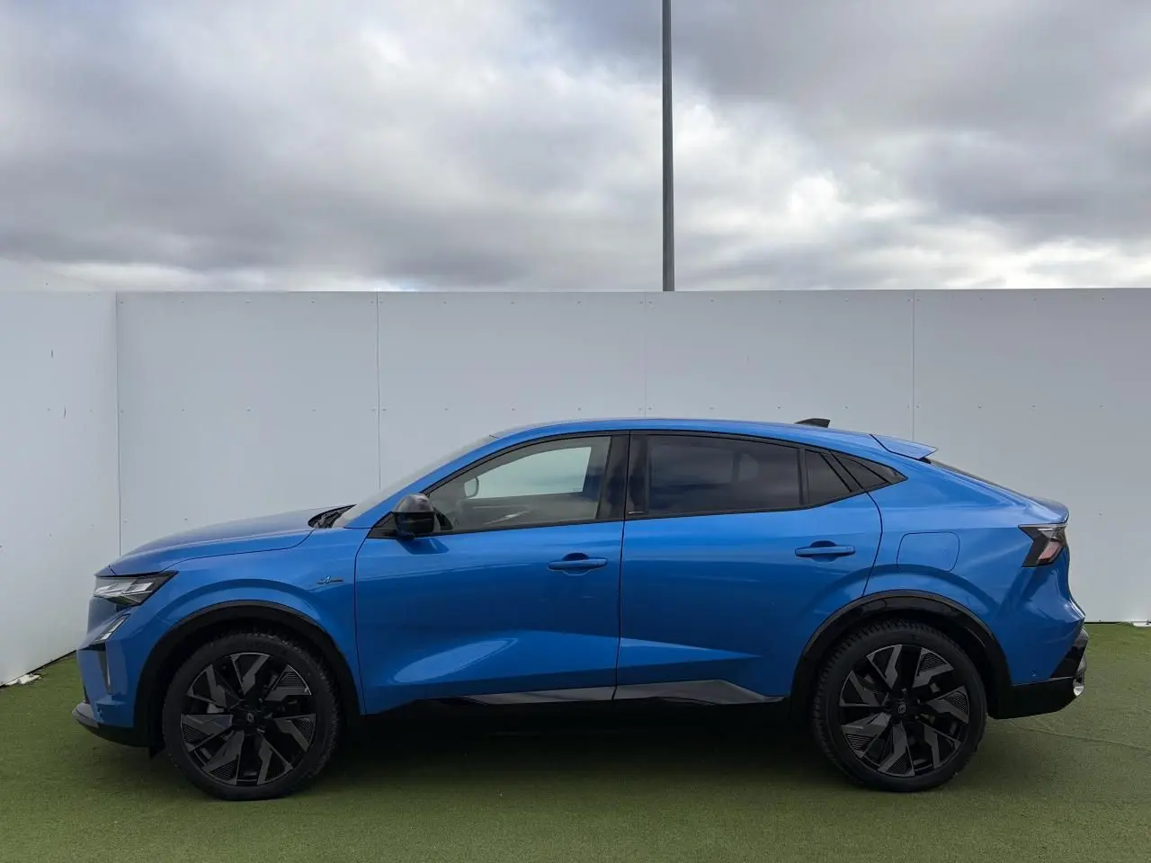 Profil droit du Renault Rafale 2025 hybride rechargeable en bleu Summit avec jantes noires diamantées.