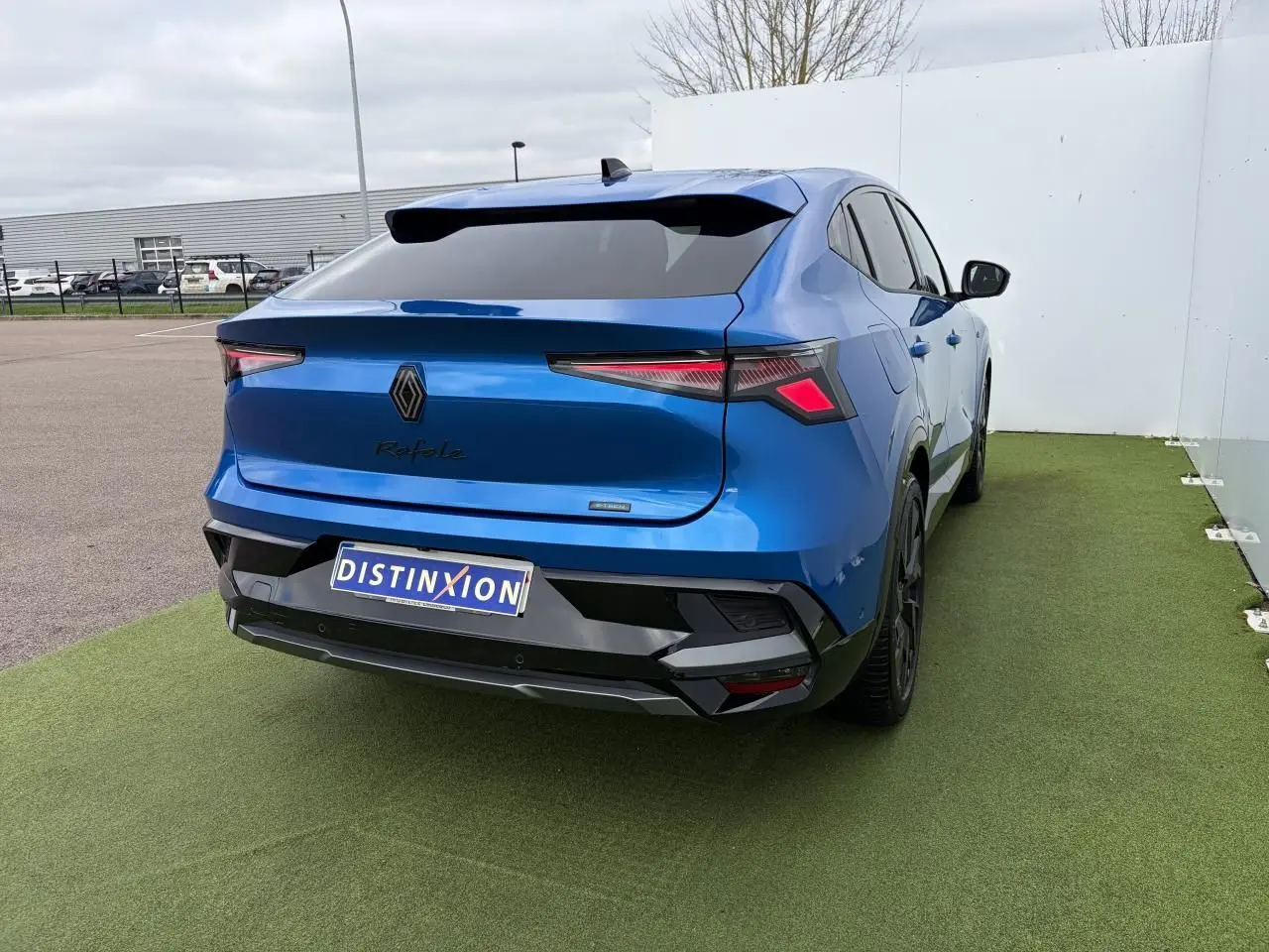 Vue 3/4 arrière droite d’un Renault Rafale bleu sommet avec feux arrière LED et jantes noires.