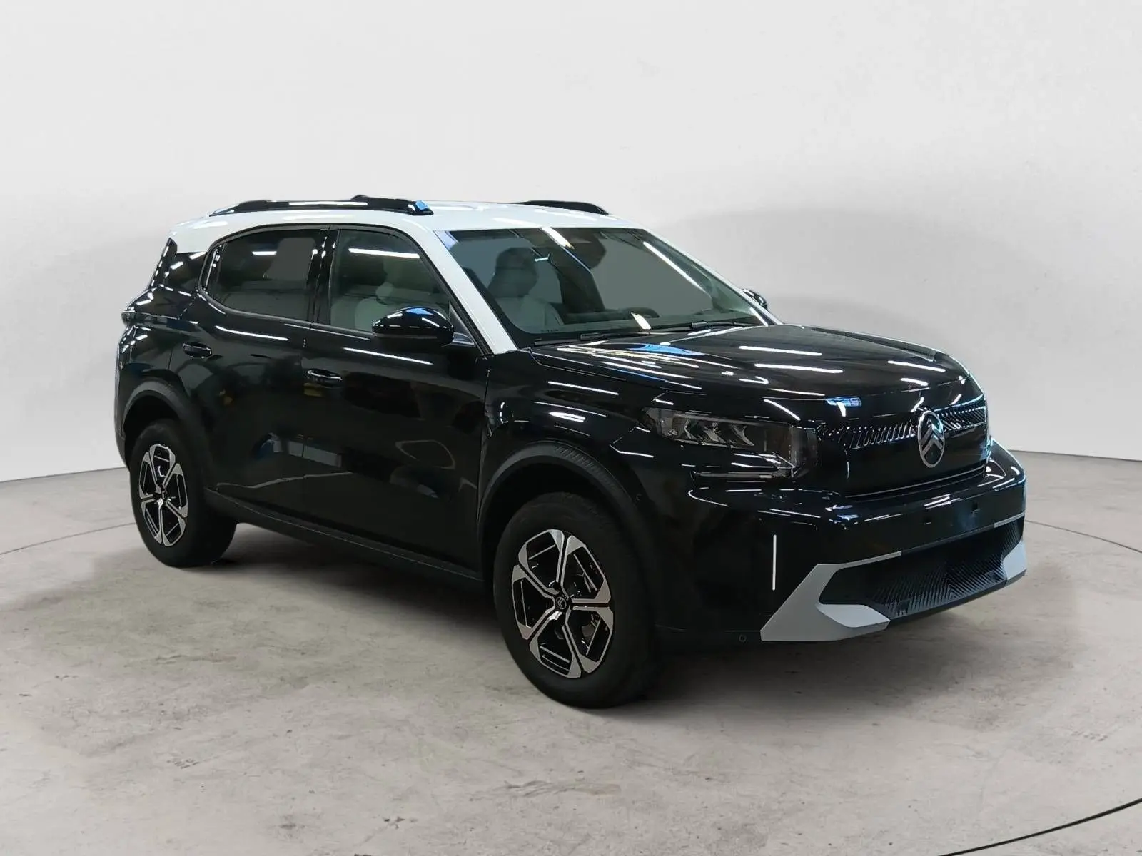 Citroën C3 Aircross hybride 2025 noir perla avec toit blanc, vue 3/4 avant côté gauche, jantes bi-ton distinctives.