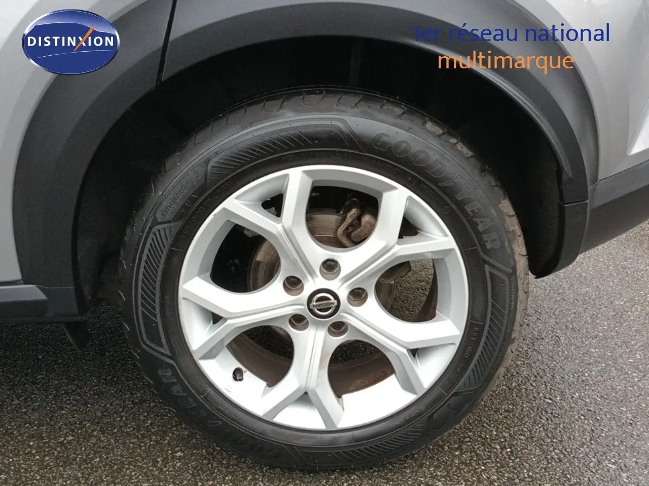 Gros plan sur la roue avant droite d’un Nissan Juke gris platine métal, mettant en valeur la jante alliage 17 pouces.