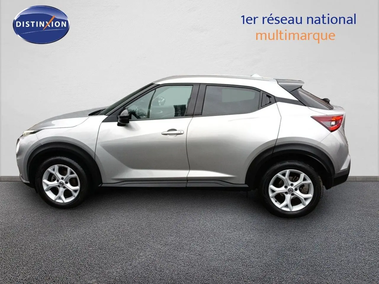 Vue de profil côté gauche d'un Nissan Juke gris platine métal, SUV compact avec jantes alliage 17 pouces.