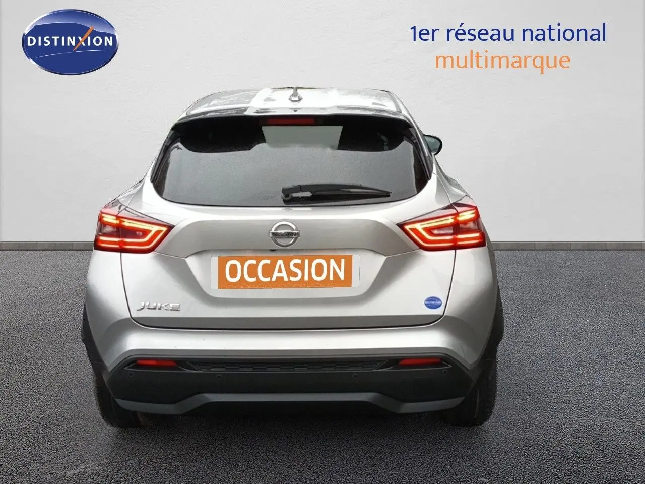Vue arrière d'un Nissan Juke gris platine métal de 2020 avec feux LED allumés et plaque "OCCASION".