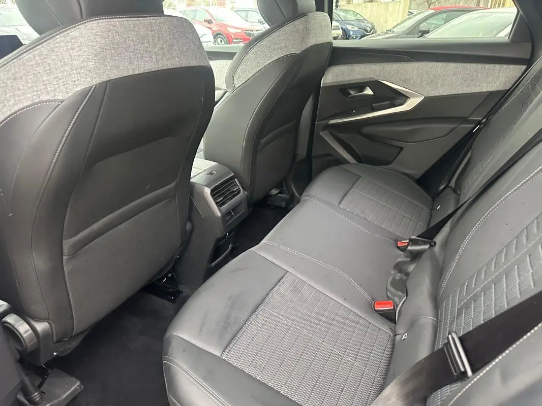Vue intérieure arrière côté droit du Peugeot 3008 Hybrid gris, montrant les sièges arrière en tissu et cuir avec ceinture de sécurité.