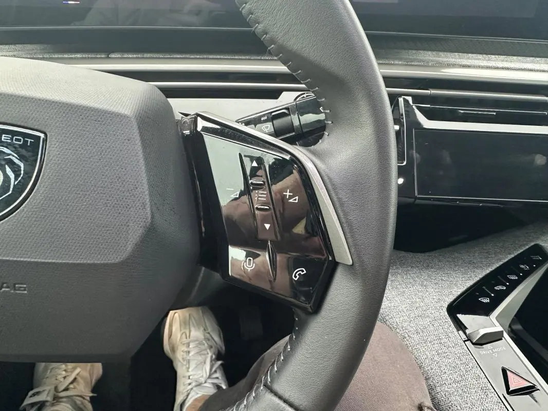 Gros plan sur le volant de la Peugeot 3008 Hybrid 136 e-DCS6 Allure 2025, montrant les commandes multifonctions côté gauche.