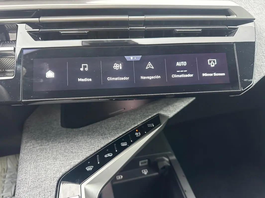 Vue rapprochée de la console centrale tactile du Peugeot 3008 Hybrid gris, affichant les commandes climatisation et multimédia.