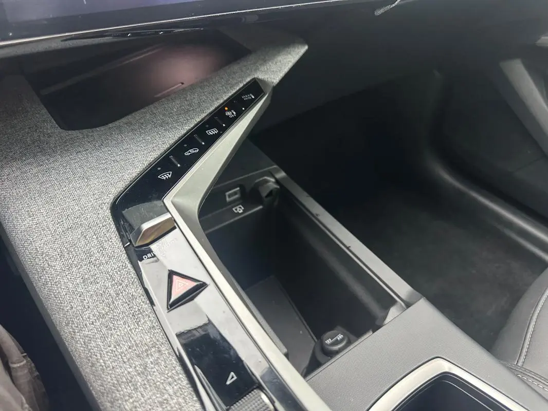 Détail de la console centrale du Peugeot 3008 Hybrid 136 e-DCS6 Allure 2025, avec commandes tactiles et finition tissu gris.