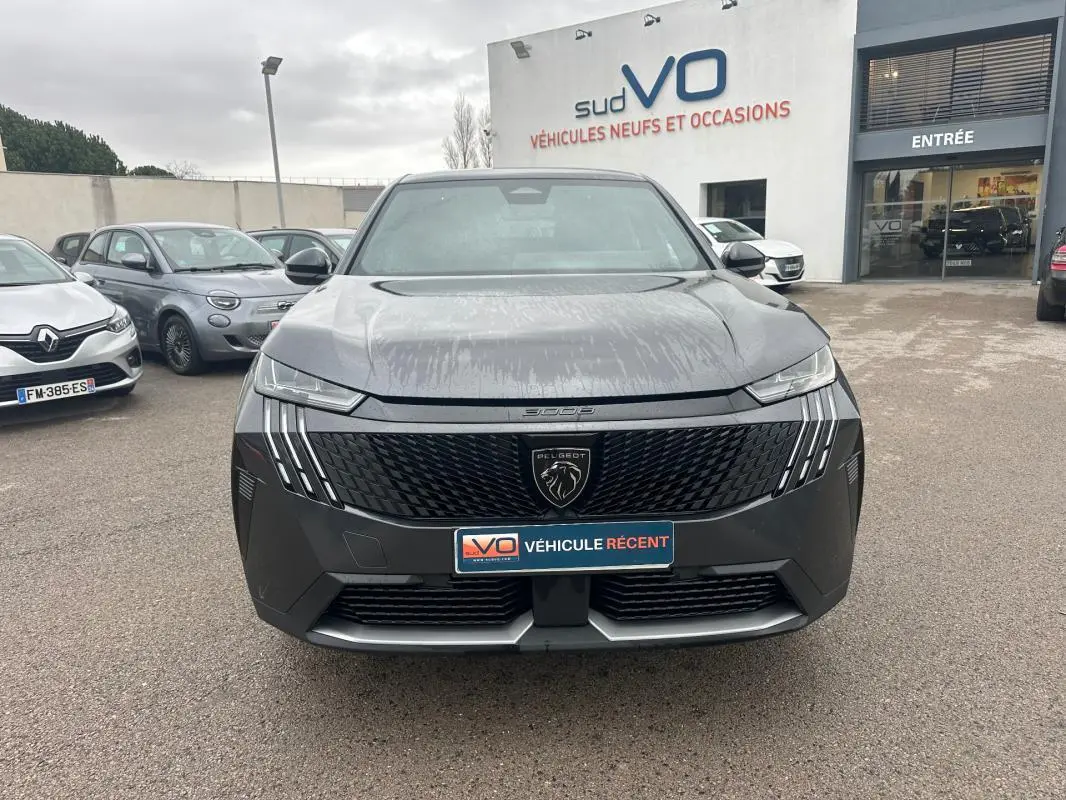 Vue avant d’un Peugeot 3008 Hybrid gris 2025 avec calandre noire et feux LED verticaux distinctifs.