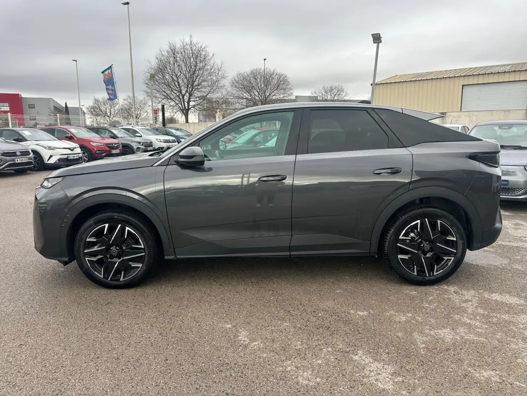 Vue de profil côté gauche d’un Peugeot 3008 Hybrid gris 2025 avec jantes alliage noires de 19 pouces.