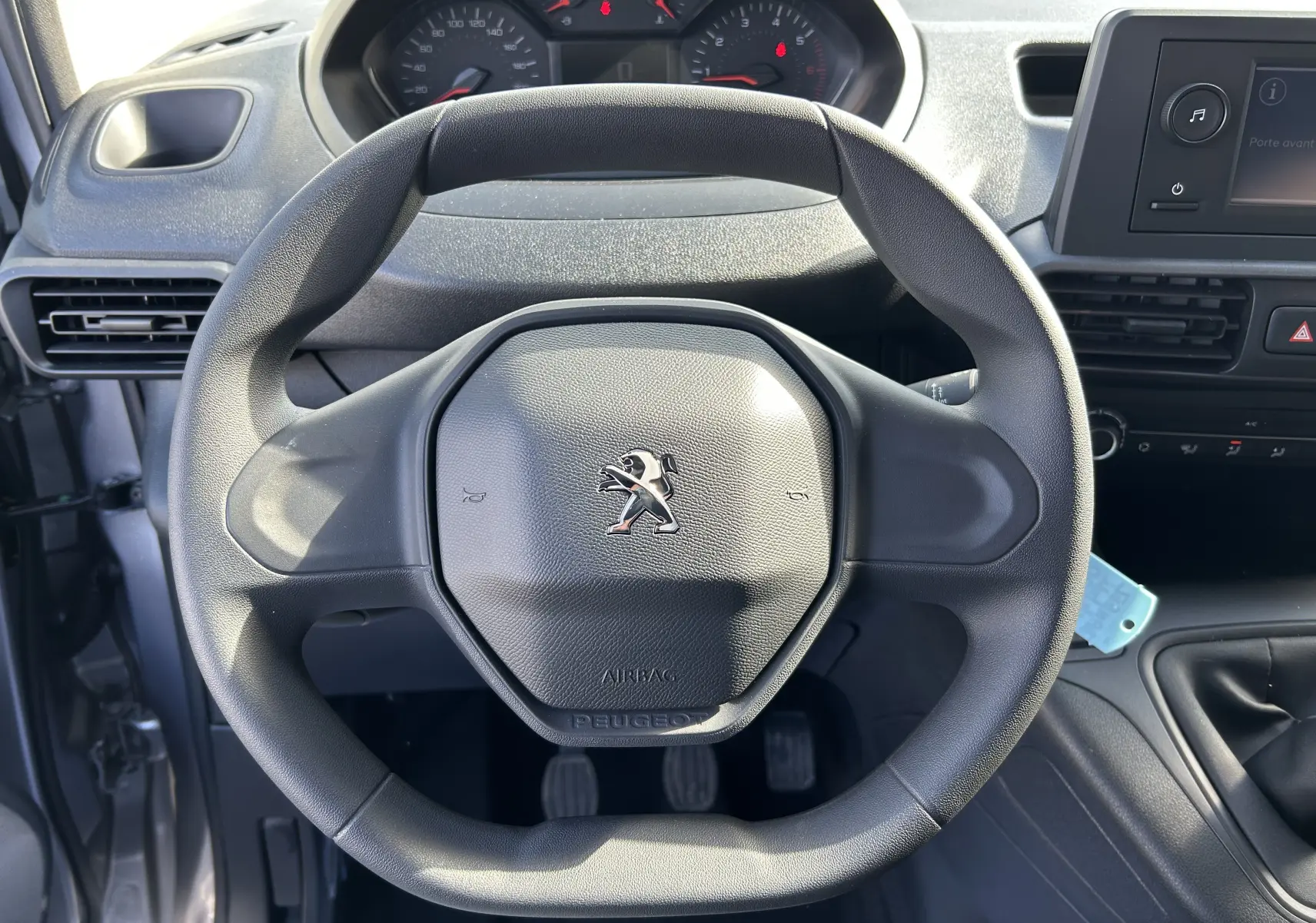 Vue intérieure centrée sur le volant Peugeot noir du Dangel Partner 4x4, avec tableau de bord et console visibles.