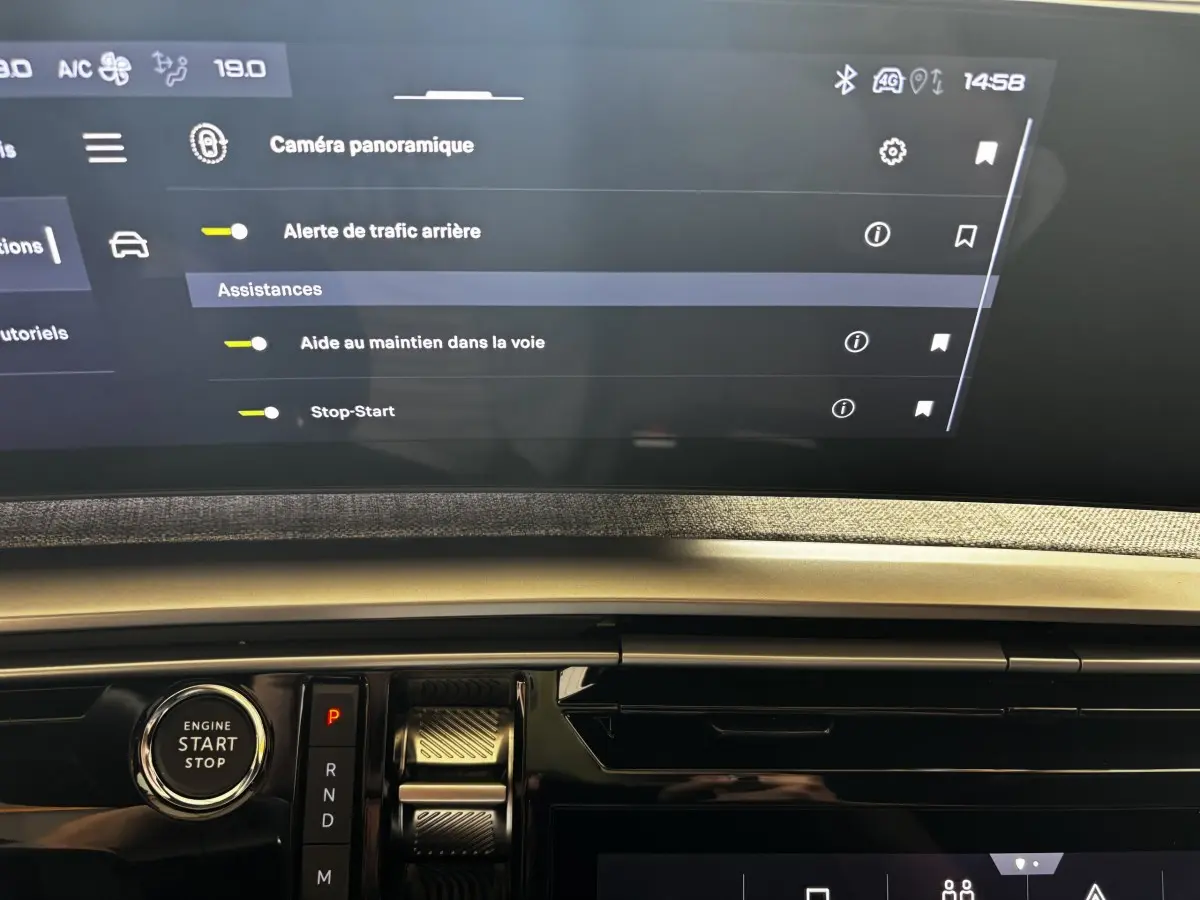 Vue rapprochée de la console centrale du Peugeot 3008 gris clair 2025, avec écran tactile et bouton démarrage visible.