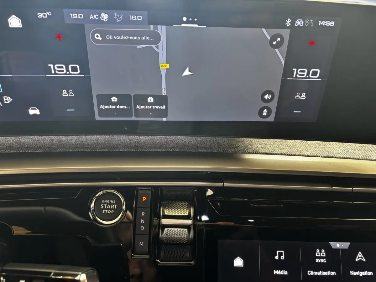 Tableau de bord du Peugeot 3008 gris clair 2025, vue rapprochée sur écran tactile et bouton démarrage.