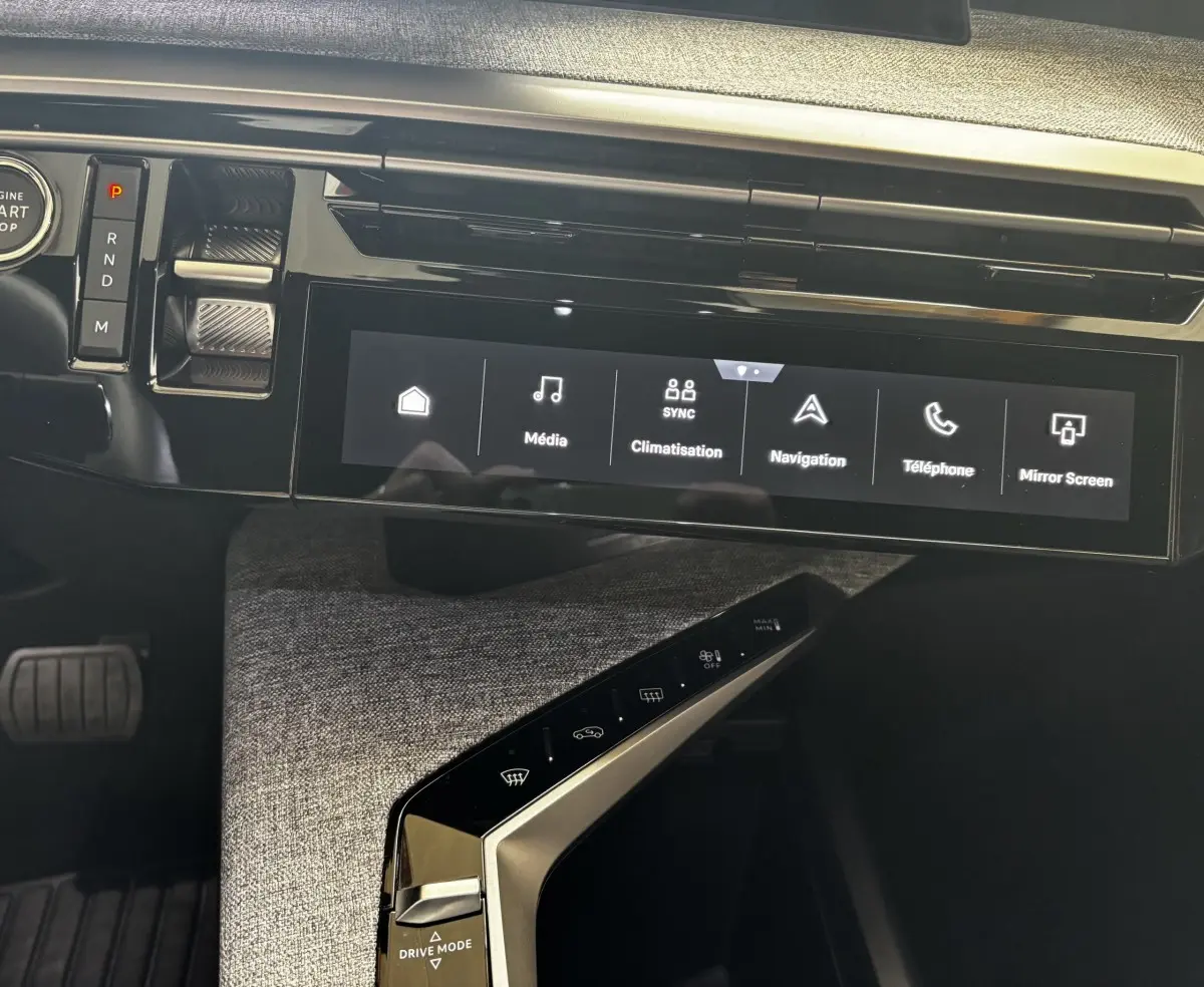 Vue intérieure du tableau de bord du Peugeot 3008 hybride 2025, écran tactile central et commandes modernes.