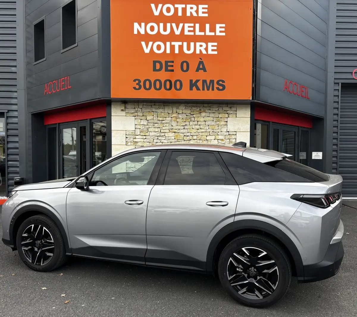 Vue de profil côté gauche d’un Peugeot 3008 gris clair 2025 avec jantes noires et toit noir contrasté.