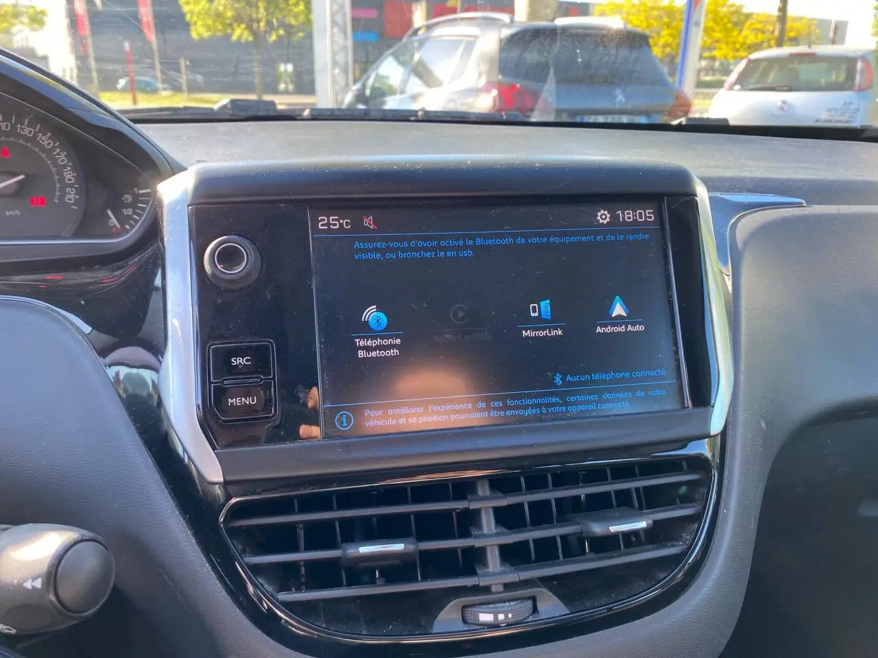 Vue rapprochée de l’écran tactile central du tableau de bord de la Peugeot 208 blanc, affichant les options Bluetooth et MirrorLink.