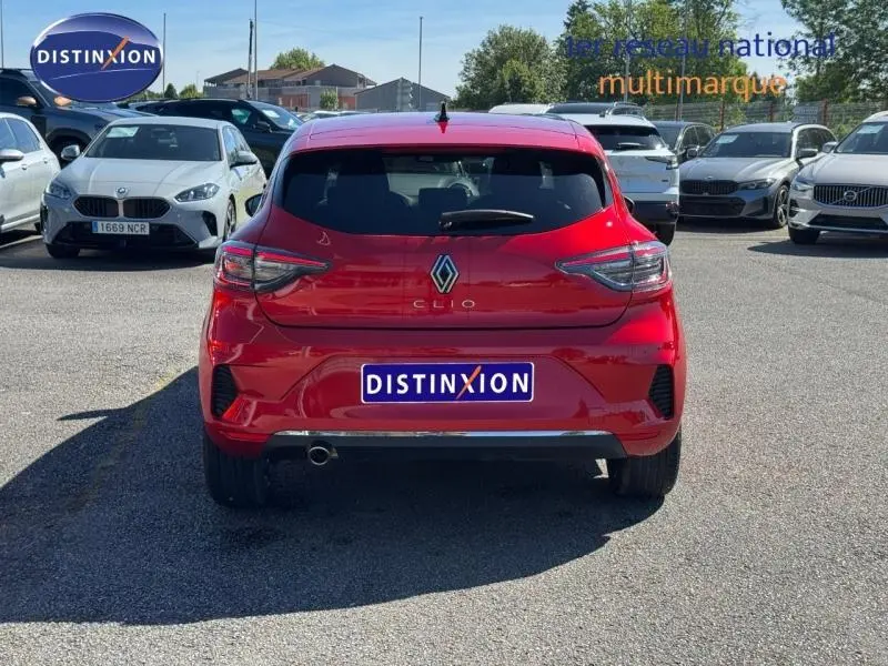 Vue arrière d'une Renault Clio rouge 2025, version 1.0 Eco-G 100ch Techno, garée sur un parking extérieur.