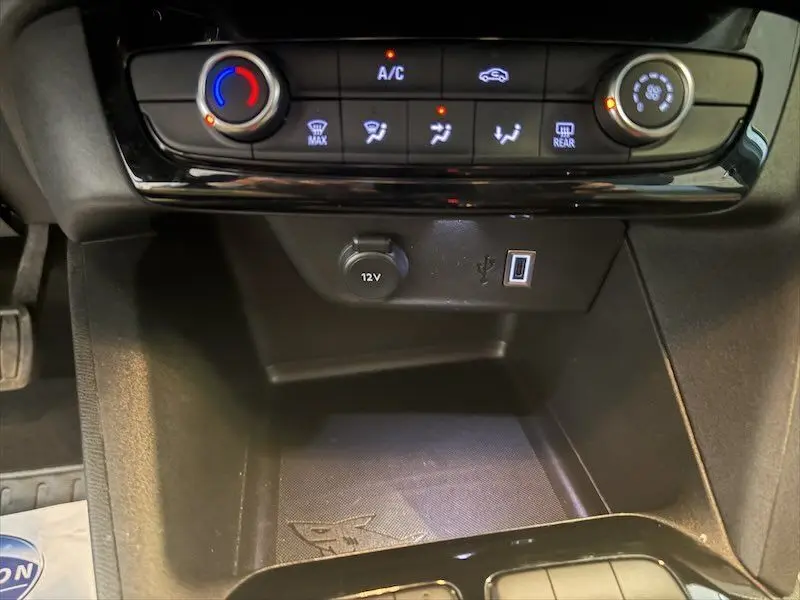 Détail de la console centrale de l’Opel Corsa 1.2 Turbo 100 Edition 2025, montrant les commandes de climatisation et prises 12V et USB.